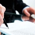 Closeup of business ladys hand with pen signing a contract